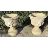 GARDEN PEDESTAL URNS, a pair, Regency style, composite stone, twin handled with cast decoration,