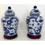 CHINESE DRAGON URNS AND COVERS, 38cm x 22cm, blue and white under glaze decoration, with stands. (2)