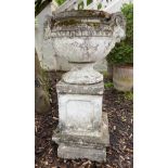 GARDEN URN, weathered reconstituted stone, Neoclassical form with goats heads handles and plinth