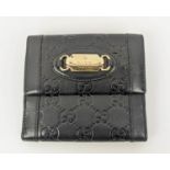 GUCCI EMBOSSED WALLET, with front logo plaque, snap closure, double rear compartments for notes,