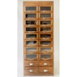 HABERDASHERY CABINET, mid 20th century English oak of narrow shallow proportions with 16 glass