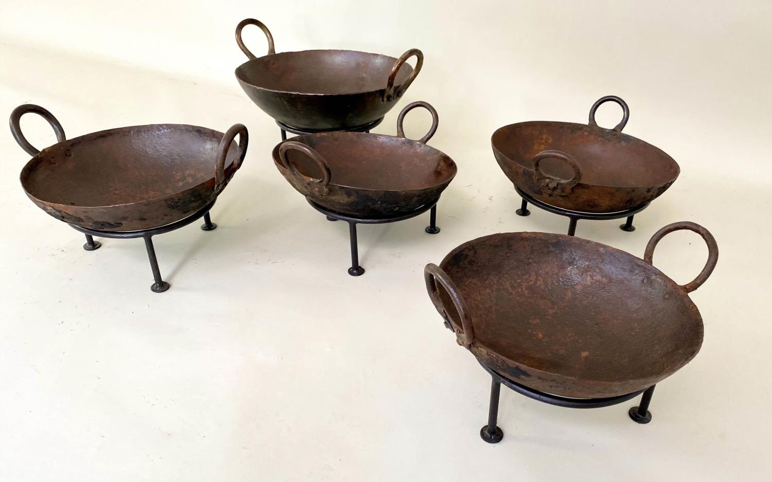 INDIAN KADAI FIRE BOWLS ON STANDS, a set of five, 46cm diam. at largest, of various sizes. (5)