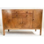 HEALS SIDEBOARD, 1950's figured walnut, with drawers and cupboards flanked by further cupboards,