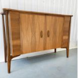 SIDEBOARD, 1960s walnut, with two lozenge incised doors enclosing filled drawers, by Everest,