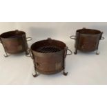 SMALL FIRE PITS, each of two handled form, raised on three feet, 22cm x 36cm x 25cm. (3)