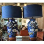 TABLE LAMPS, a pair, 79cm H x 49cm W, blue ceramic with white floral low relief decoration, blue