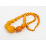 BUTTERSCOTCH AMBER NECKLACE, fitted with 49 graduated oval beads, 69cm long, yellow metal clasp,