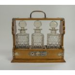 TANTALUS, Victorian oak, silver plated mounts with three cut glass decanters with faceted
