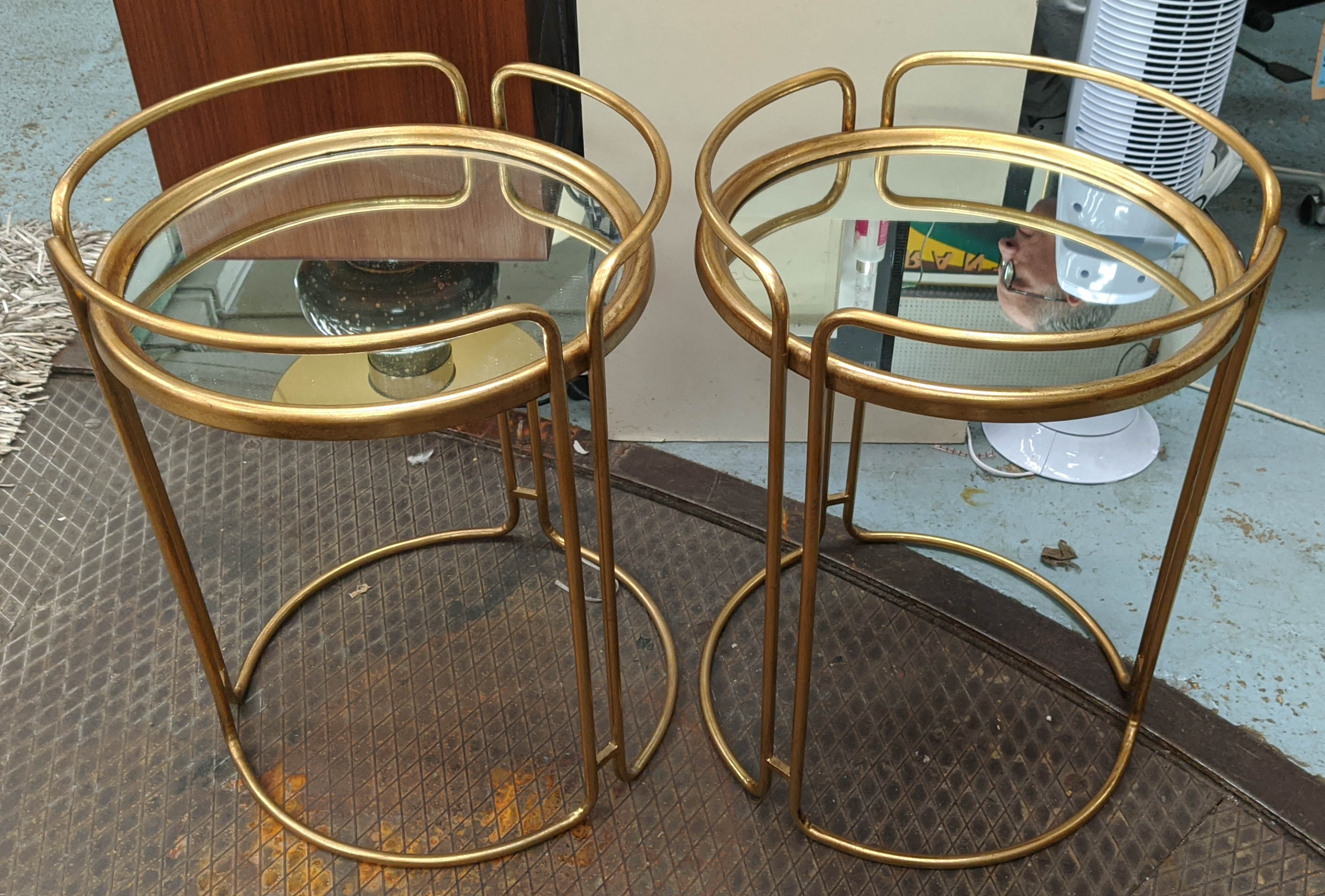 SIDE TABLES, a pair, 64cm x 48cm diam., 1970s Italian style, gilt metal, mirrored top. (2)