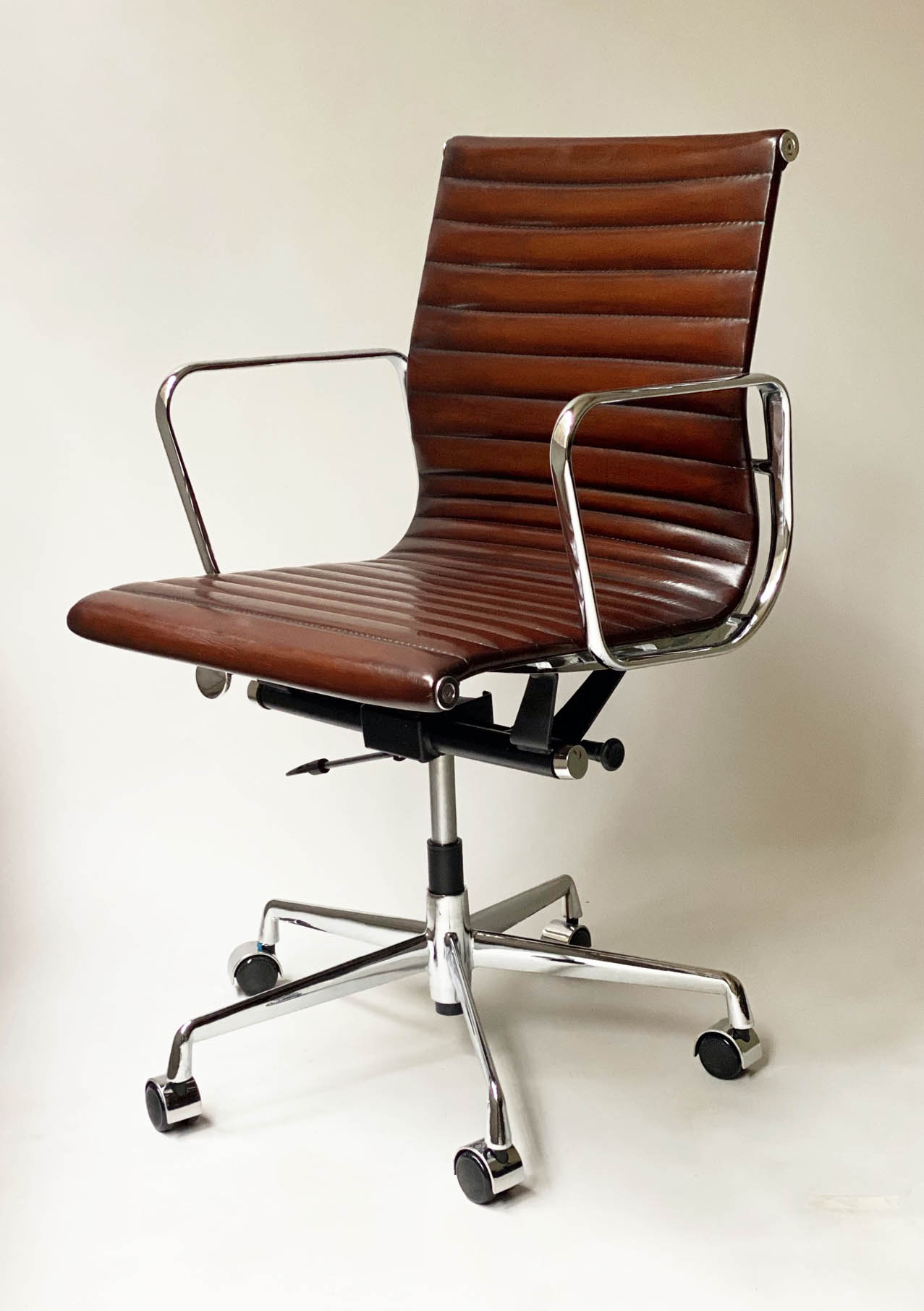 REVOLVING DESK CHAIR, Charles and Ray Eames inspired ribbed, mid brown leather, revolving and
