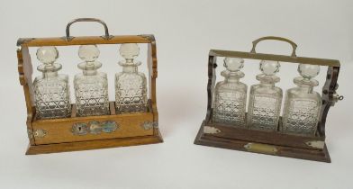 TANTALUSES , two, one Victorian oak, with silver plated mounts and three cut glass decanters