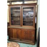 BOOKCASE, late 19th century oak, the upper section with sliding glazed doors, the base with