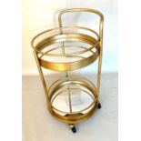 COCKTAIL TROLLEY, 77cm high, 42cm diameter, 1960s French style, gilt metal frame with glass shelves