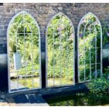 ARCHITECTURAL GARDEN MIRRORS, a set of three, 160cm high, 67cm wide, arched aged metal frames with