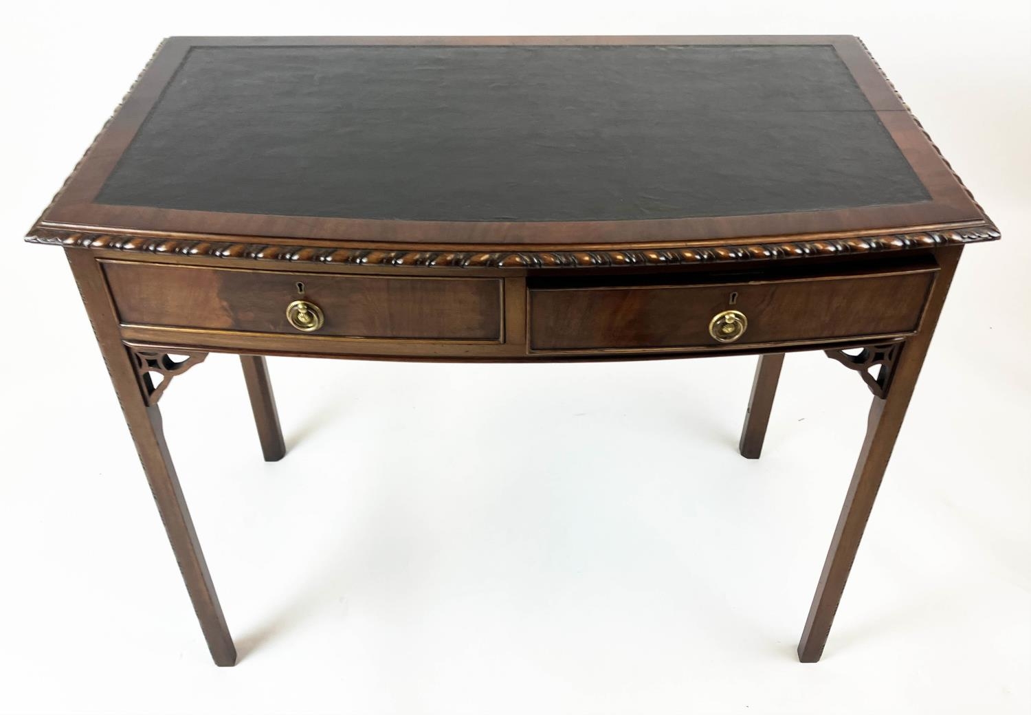 BOWFRONT SIDE TABLE, early 20th century George II style, mahogany with two drawers with leather