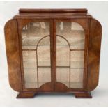 ART DECO DISPLAY CABINET, walnut with a pair of arched glazed doors enclosing glass shelves, 122cm W