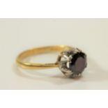 An 18 carat gold garnet and diamond cluster ring