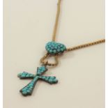 A turquoise pendant in the form of a cross on a neck chain