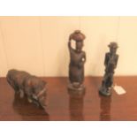 An African wooden carving of a Rhinoceros, 22cm, and two figures, 27cm and 23cm (3)