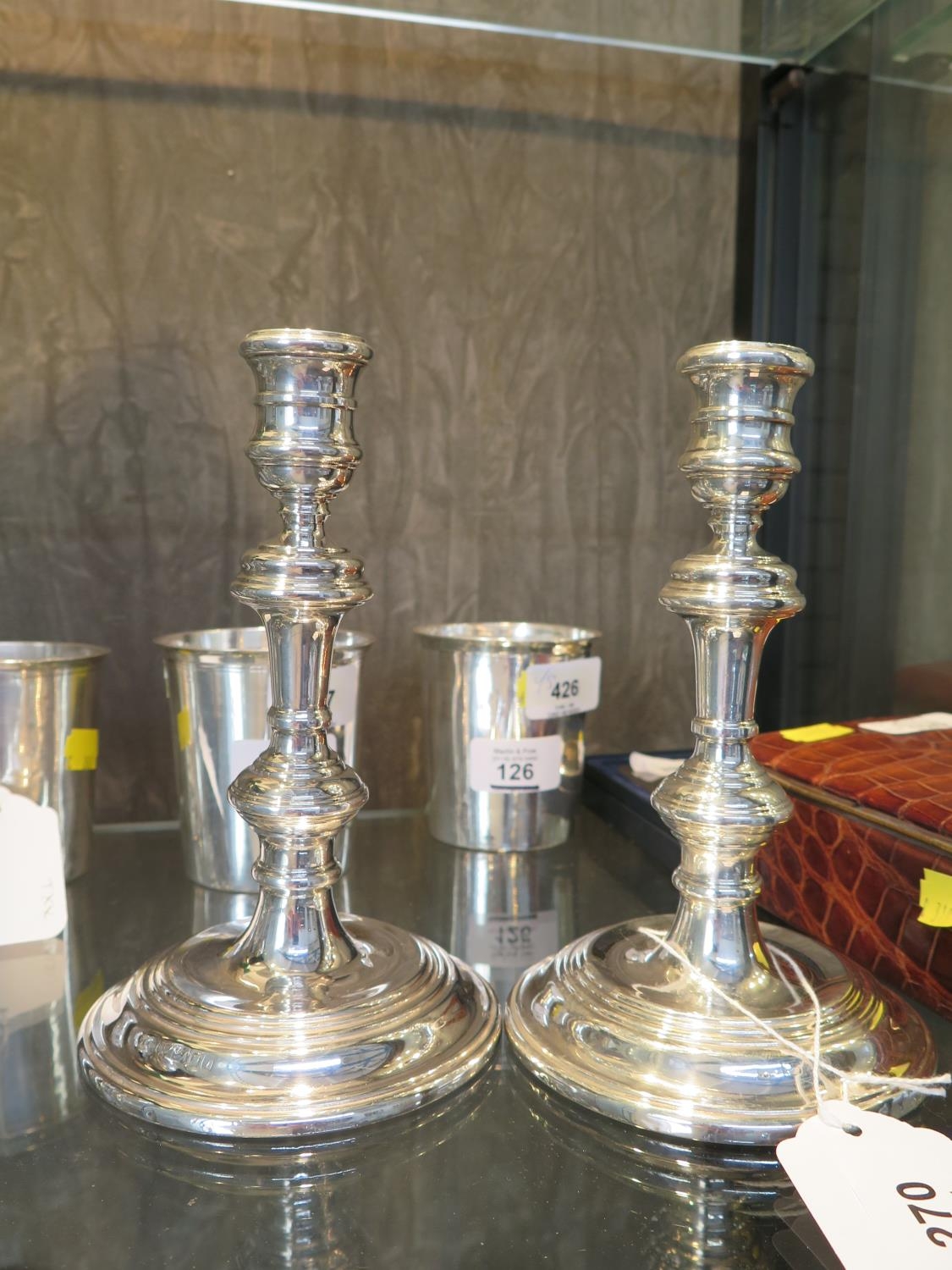 A pair of silver candle sticks. 18cm high