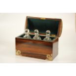 A Rosewood Tantalus. Of casket form. Fitted with three decanters with stoppers. Complete with key.