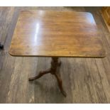 A Victorian Mahogany Tripod Table. With a rectangular top and turned column. On down swept supports.