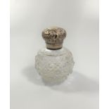 A glass perfume bottle with silver lid