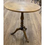 A Victorian Mahogany Tripod Table. With an oval top and turned column. On down swept supports