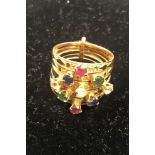 A 5 division 18ct gold ring, gem set with rubies, sapphires, emeralds etc