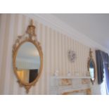 A Pair of Antique Giltwood Wall Mirrors. . Each surmounted by a Classical urn.