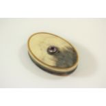 An Antique Horn Snuff Box. 19th century. Of oval form, the detachable cover inset with a coloured