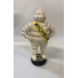A Cast Iron Michelin Man. Vintage. Shown standing on a wheel. 39cm high