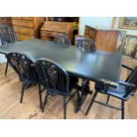 An ebonised dining table and chairs. 20th century. 74cm x 179cm x 90cm