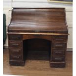 A Late Victorian Oak Tambour front desk. With a fitted interior above single frieze drawer flanked