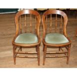 Two spindle backed, green padded seat chairs