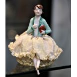 A porcelain doll with fabric skirt 14cm