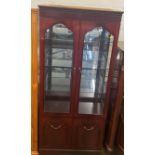 A Modern mahogany veneered glazed display cabinet. With interior lights. 187cm x 80cm x 42cm