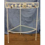 A metal painted white triangular corner table with leaf decoration and two glass shelves 75cm