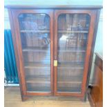 A late Victorian Display Cabinet. Circa 1890. With a pair of glazed doors enclosing four shelves.