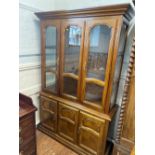 A Modern Display cabinet. With a pair of glazed doors enclosing shelves, above three cupboard doors.