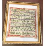 A Victorian sampler by Emily Butler 1877 in a later frame.