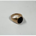A 14k gold signet ring set with black stone size M.