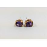 A pair of gold ear rings set with amethyst.
