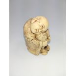 A late 19th century bone carving of a Japanese boy, resting.