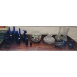 Two glass bowls, glass marbles, and mixed glassware including blue bottles and drinking glasses.