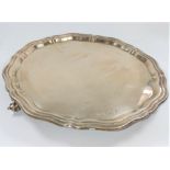 A silver salver some 21cm in diameter with gadrooned edge sat on three feet. Sheffield 1958