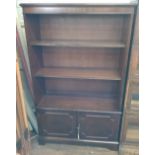 An Open Bookcase of two shelves above a two door cupboard. Approx.140 x 85 x 30cm