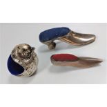 Two silver pin cushions in the form of shoes, together with a white metal pin cushion in the form of