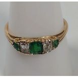 An emerald and diamond 3 stone ring set in 18ct gold. Size R.