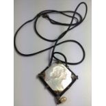 A mother of pearl pendant showing the face of a 1920's lady.